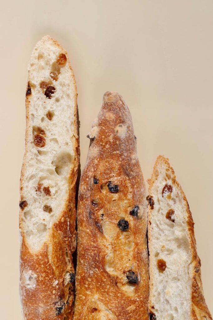 Close-up of three sliced French baguettes with raisins, showcasing texture and freshness.